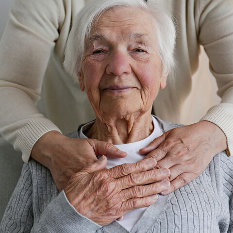 ältere Frau die herzlich von hinten berührt wird